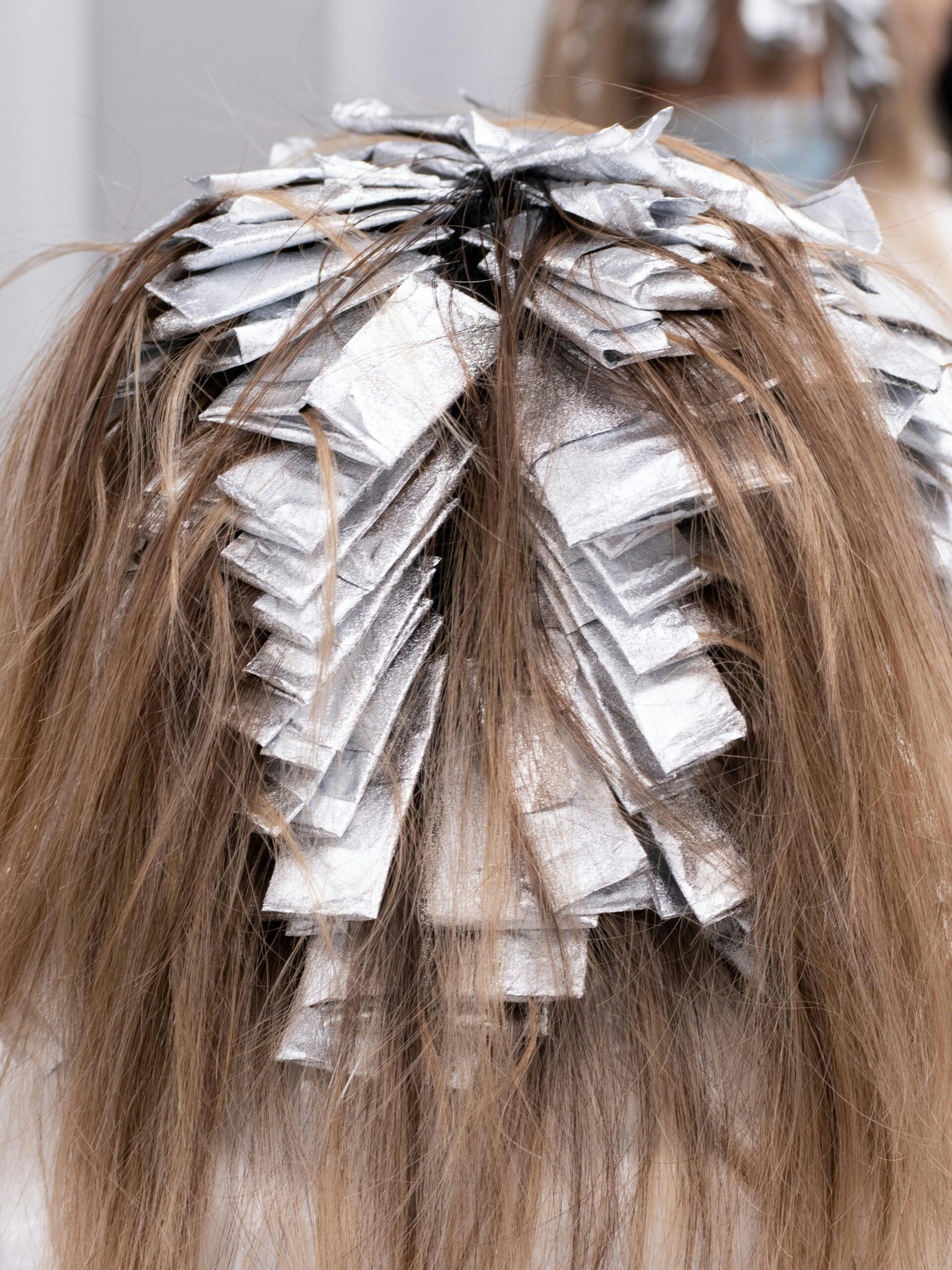 Back of a client’s head with foils in her hair who is having partial coverage colour treatment at the hairdressers