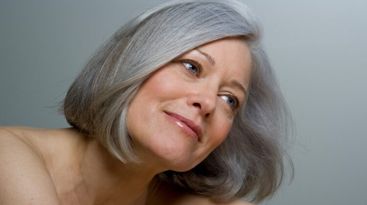 Close-up of a woman with a smooth grey bob hairstyle and natural makeup