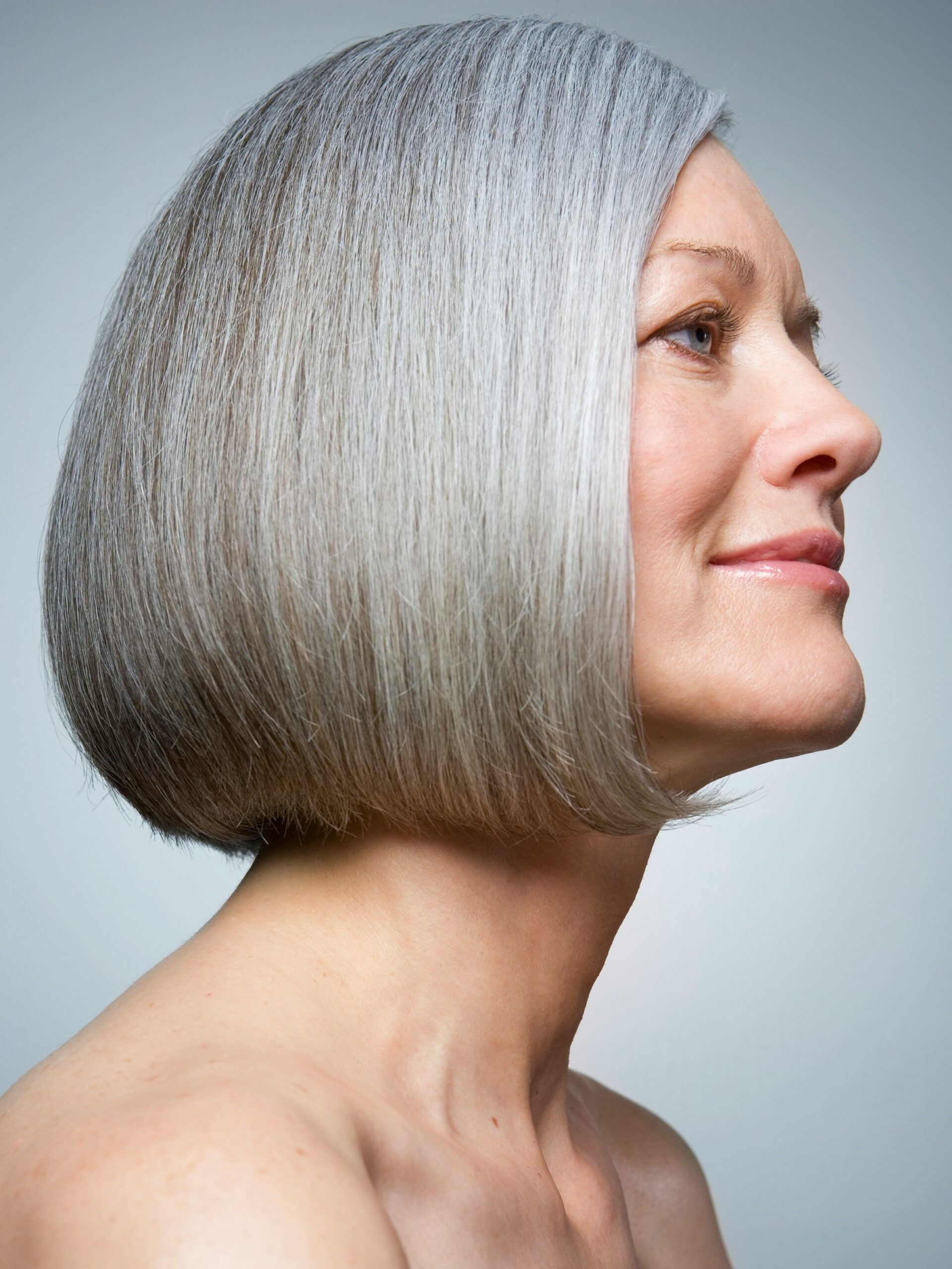 Side-on portrait of woman with a healthy and shiny grey bob