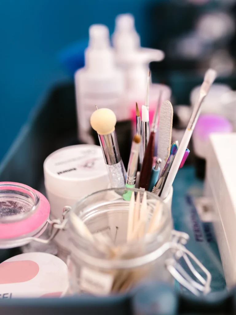 Close-up of a nail tech's workstation in a salon showing manicure tools, brushes and products
