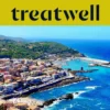 Aerial view of a Sardinian coastal town with pastel houses, a harbour and turquoise sea.