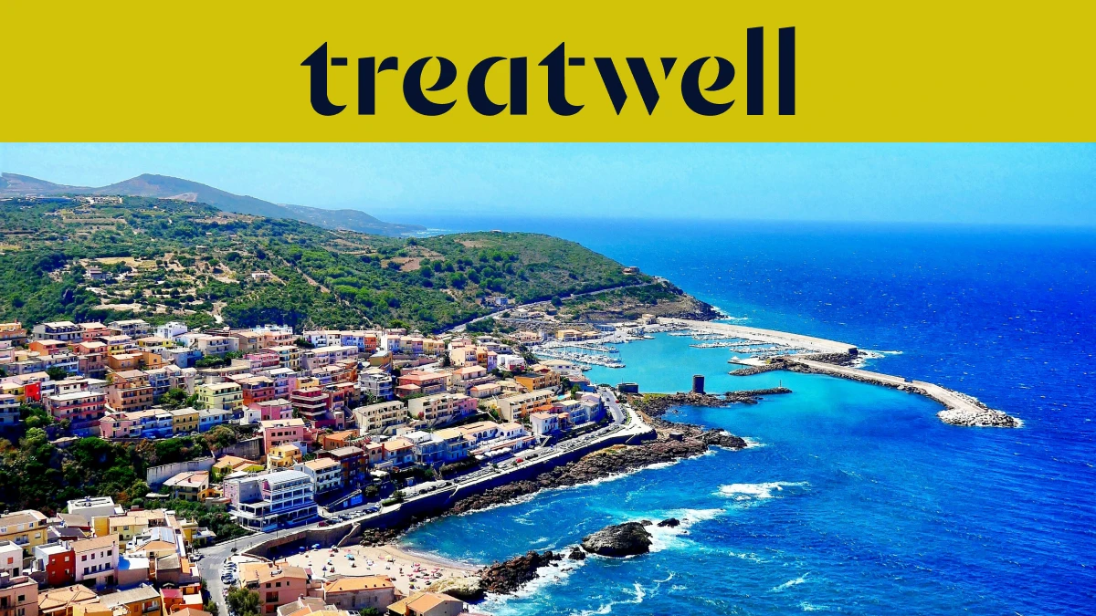 Aerial view of a Sardinian coastal town with pastel houses, a harbour and turquoise sea.