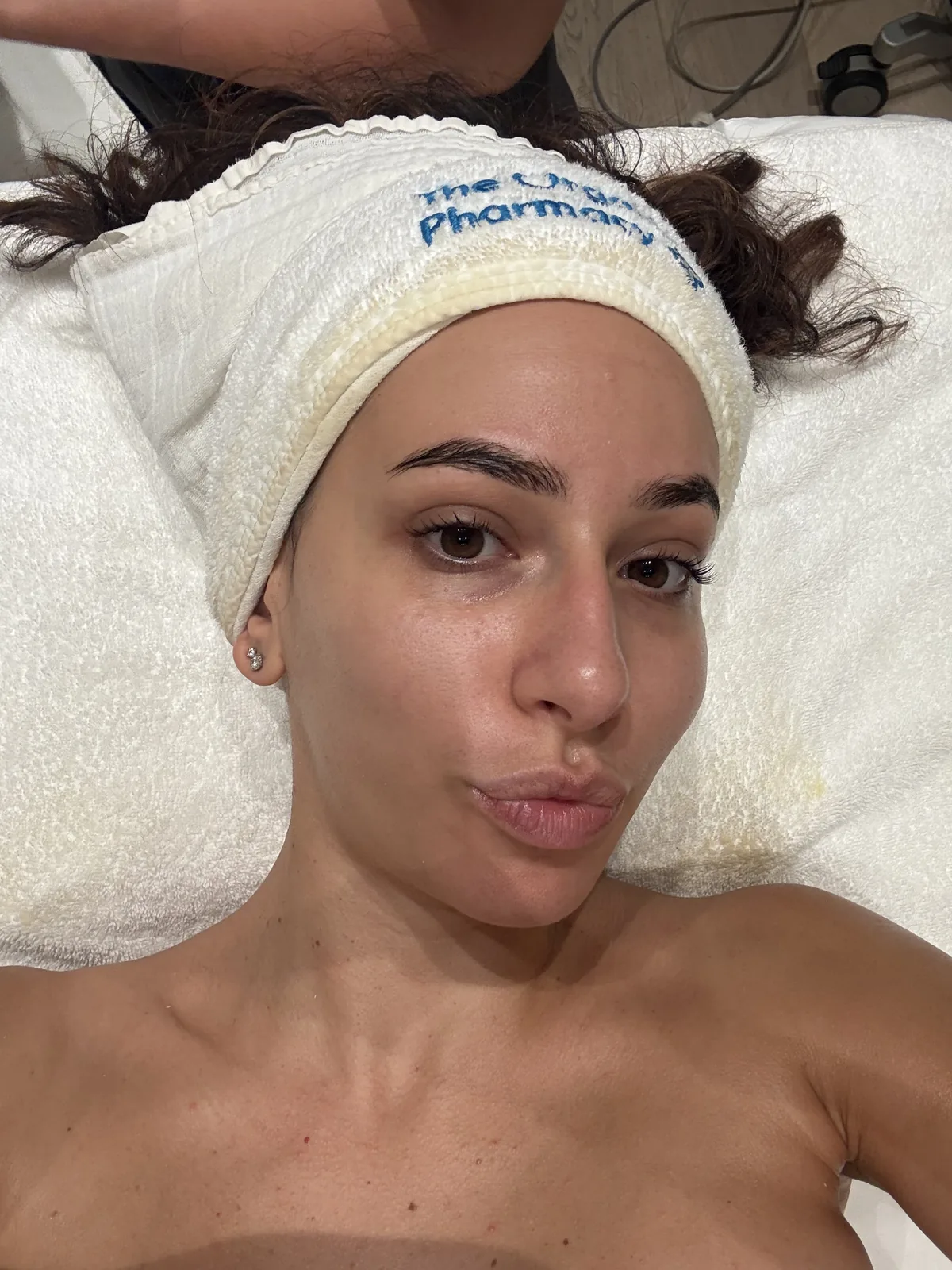 Woman with fresh, dewy skin wearing a headband during a facial
