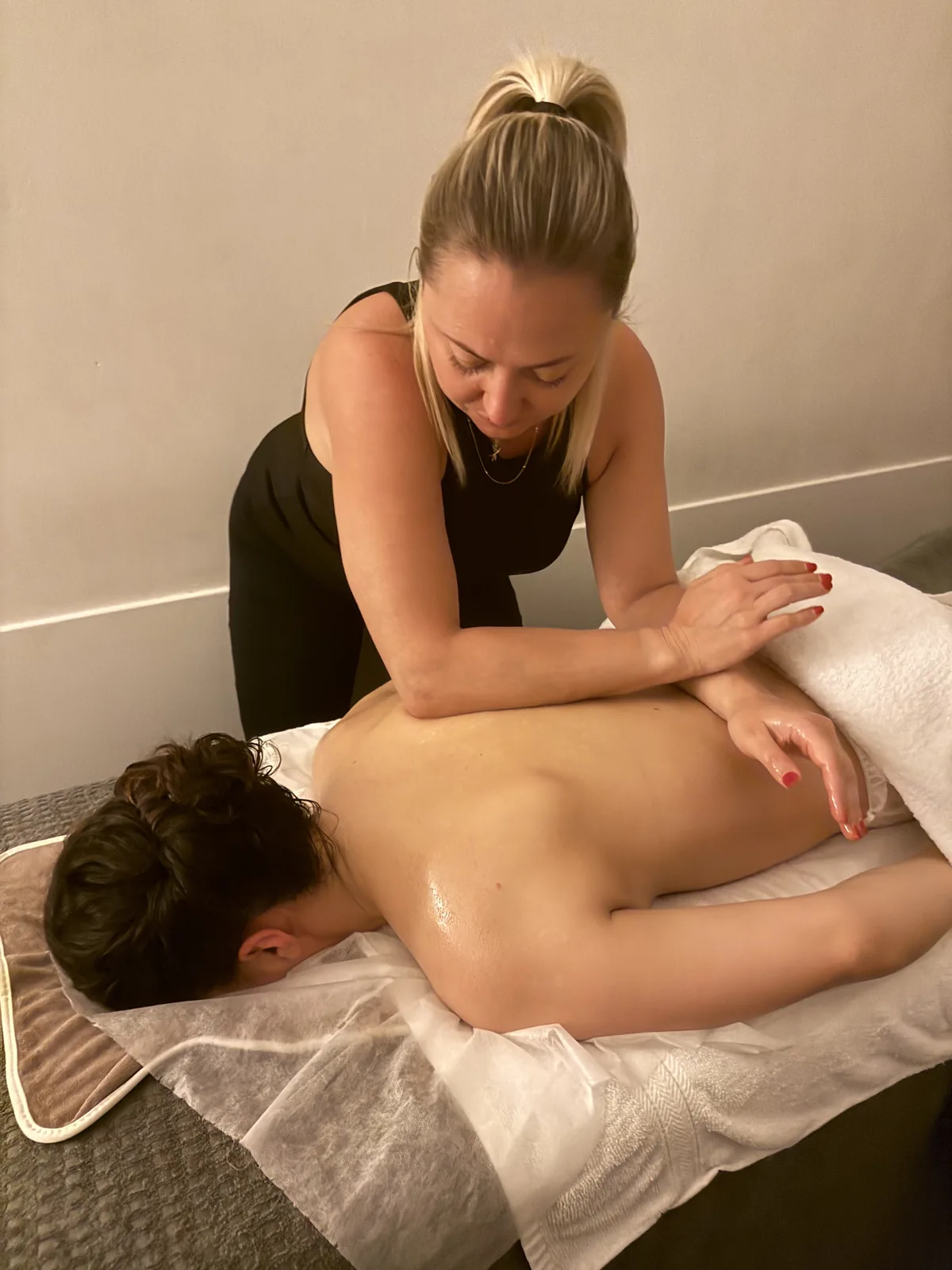 Therapist giving a back massage on a treatment table