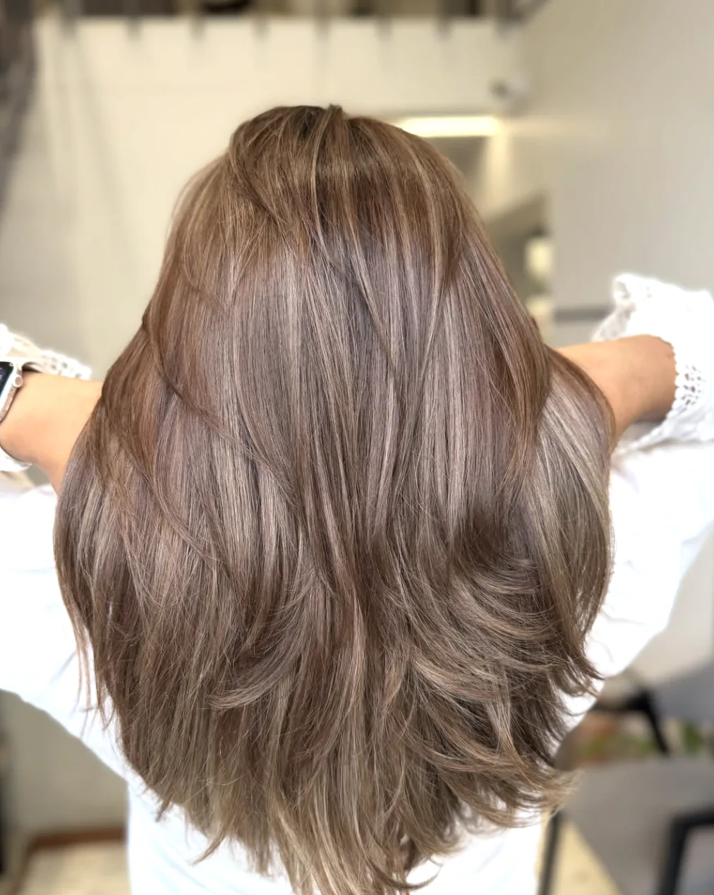 Long, layered hair in a multi-tonal taupe truffle brunette shade